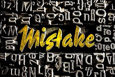 Old lead letters with golden writing show the word Mistake, Germany, Europe