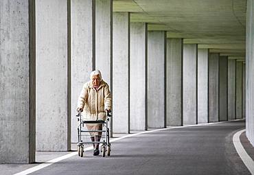 Senior citizen with walker walks in an underpass, Austria, Europe