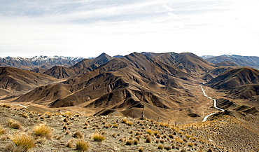 Stark mountain landscape with mountain road, Lindis Pass, Southern Alps, Otago, Southland, New Zealand, Oceania