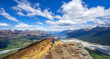 Hiker on the summit of Mount Alfred, views of Lake Wakatipu and mountain scenery, Glenorchy near Queenstown, Southern Alps, Otago, South Island, New Zealand, Oceania