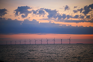 View from Amager beach to wind turbines in the sea at sunrise, offshore wind farm, Copenhagen, Denmark, Europe