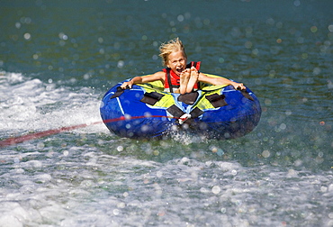 Girl rafting with water hoops in a lake, Lake Mondsee, Upper Austria, Austria, Europe