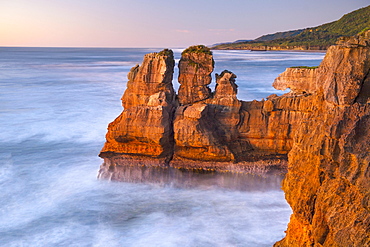 Rock formations on the coast of Paparoa National Park in red evening sun, Punakaiki, Runanga, West Coast, New Zealand, Oceania