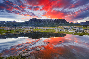 Mountain range reflected in the lake in evening mood with red clouds, Gaellivare, Norrbottens laen, Sweden, Europe