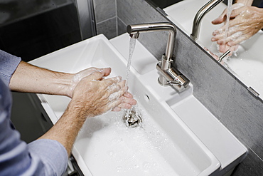 Man washing his hands at the sink