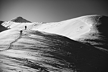 Two tourists on the approach under Rakoń peak winter road, Tatra National Park, Poland, Europe