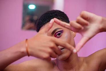 Young man with make-up makes gesture with his hands, South Africa, Africa