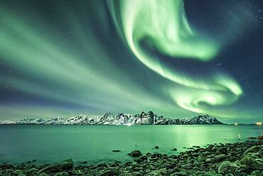 Northern lights over the sea and snow-covered mountains, Vesteralen, Nordland, Norway, Europe