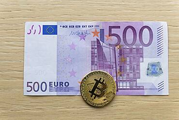 Symbol image digital currency, physical coin Bitcoin, on euro banknote