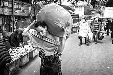 Bang-bang carriers in a market at the port of Chongqing, the carriers are like a caste of their own, carrying loads for the traders for little money, mostly immigrant workers from rural areas, Chongqing, China, Asia