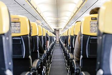 Empty corridor in the airplane with all passengers sitting down