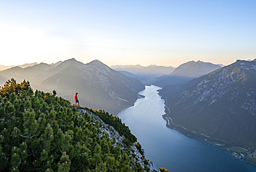 Young man looking over mountain landscape, view from the top of the Baerenkopf to the Achensee, left Seekarspitze and Seebergspitze, Karwendel, Tyrol, Austria, Europe