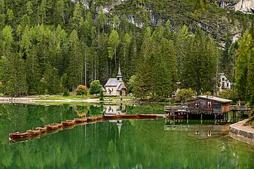 Chapel and boathouse with rowing boats at the Lake Prags Lake, Lago di Lake Prags, Lake Prags Valley, Lake Prags, Dolomites, South Tyrol, Alto Adige, Italy, Europe