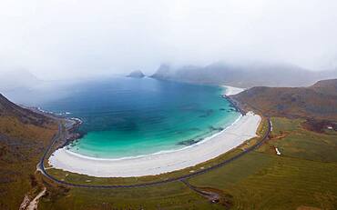 Drone shot, White sand beach with sea, mountains and orange grass, Haukland beach, Lofoten, Norway, Europe