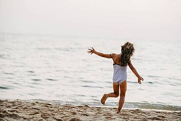 Happy girl on sandy beach, sea