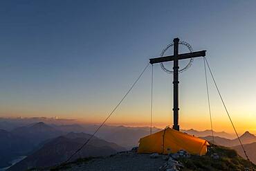 Sunset over Lechtal mountains, in the foreground summit cross of the Geierkopf with tent, Reutte, Ammergau Alps, Tyrol, Austria, Europe