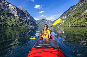 Young woman paddling in a kayak, Geirangerfjord, near Geiranger, Norway, Europe