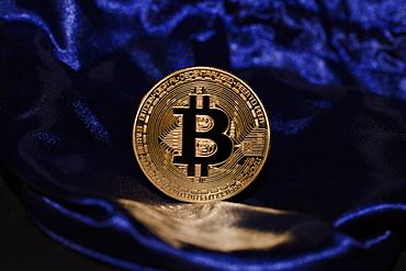 A bitcoin on blue velvet, Germany, Europe