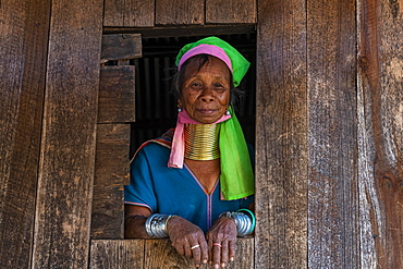 Padaung, giraffe, woman standing in a window frame of her house, Panpet, Loikaw area, Kayah state, Myanmar, Asia