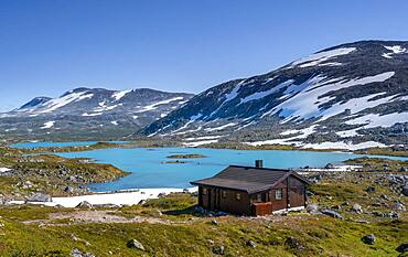 Turquoise lake and mountains, cabin on the Norwegian Landscape Route, Gamle Strynefjellsvegen, between Grotli and Videsaeter, Norway, Europe
