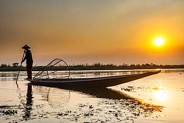 Fisherman at Inle Lake with traditional Intha conical net at sunset, fishing net, leg rowing style, Intha people, Inle lake, Shan state, Myanmar, Asia