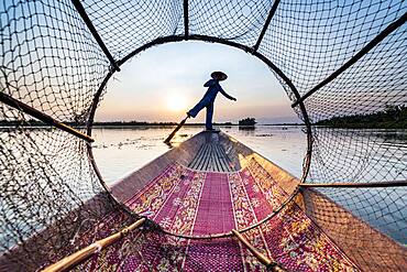 Fisherman at Inle Lake with traditional Intha conical net at sunset, fishing net, leg rowing style, Intha people, Inle lake, Shan state, Myanmar, Asia