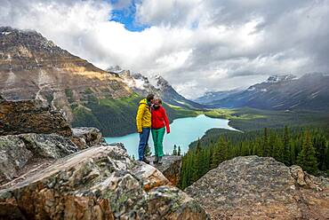 Couple kissing, view of turquoise glacial lake surrounded by forest, Peyto Lake, Rocky Mountains, Banff National Park, Alberta Province, Canada, North America