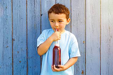 Child little boy drinking cola lemonade drinking bottle, germany