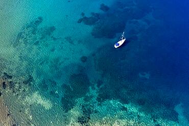 Aerial of a sailing boat in the clear waters of Limnionas beach, Samos, Greece, Europe