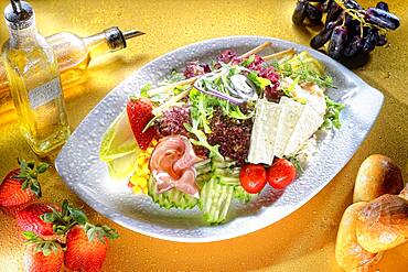 Mixed salad with cheese and ham on plate