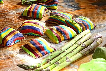 Homemade colorful ravioli on floured wooden table, Germany, Europe