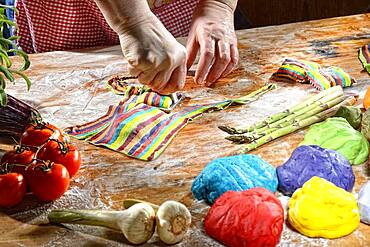 Cook cutting out fresh colorful ravioli with ravioli cutter, pasta, Germany, Europe