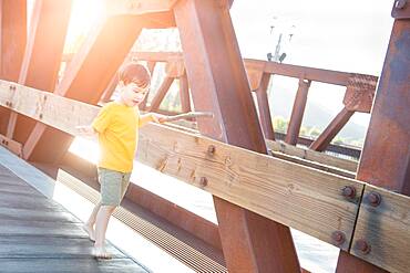 Mixed Race Chinese and Caucasian Boy Playing Alone on Bridge