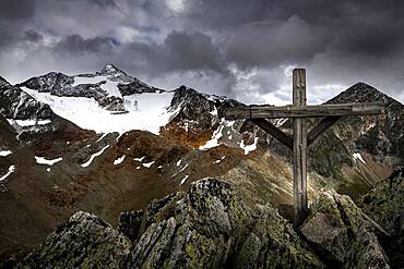 Summit cross at Falkengrat with Oetztal mountains and dramatic sky, Soelden, Oetztal, Tyrol, Austria, Europe