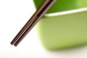 Chopsticks & green bowl on a white background