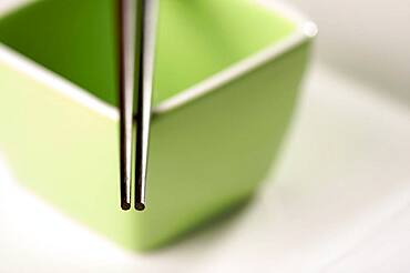 Chopsticks & green bowl on a white background