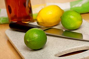 Limes, lemons and knife on cutting board