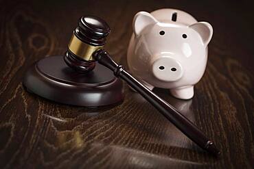 Gavel and piggy bank on wooden table