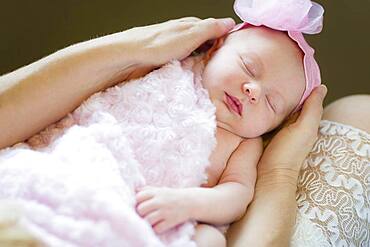 Gentle hands of mother holding her precious newborn baby girl