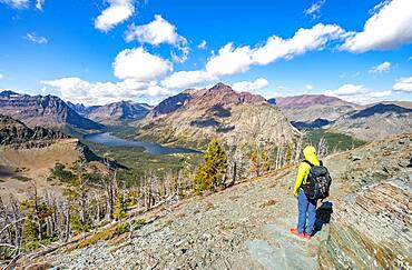 Hikers on the trail to Scenic Point, view of Two Medicine Lake, mountain peaks Rising Wolf Mountain and Sinopah Mountain, Glacier National Park, Montana, USA, North America