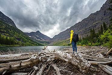 Hikers at Upper Two Medicine Lake, mountain peak Lone Walker Mountain in the back, dramatic clouds, Glacier National Park, Montana, USA, North America