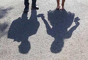 Shadow image of bride and groom on asphalt path, Germany, Europe