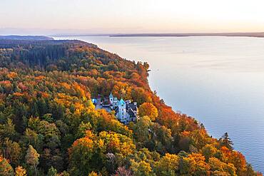 Seeburg Castle at Lake Starnberg in the evening light, near Muensing, autumnal mixed forest, Fuenfseenland, aerial view, Upper Bavaria, Bavaria, Germany, Europe