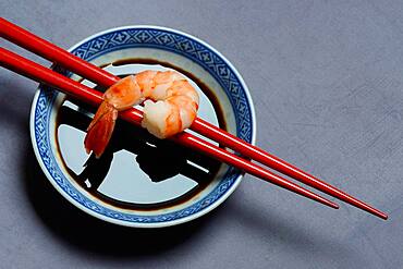 Cooked shrimp on chopsticks and shell with soy sauce, Germany, Europe