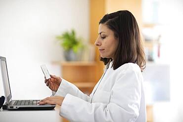 Pharmacist with medicine in a pharmacy working with modern technology and smock, Freiburg, BW