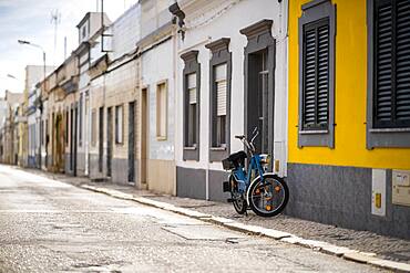 Vintage motorbike parked by typical fisherman's house in Olhao, Algarve, Portugal, Europe