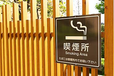 Wooden fence with smoking area sign in a business district in Tokyo, Japan, Asia