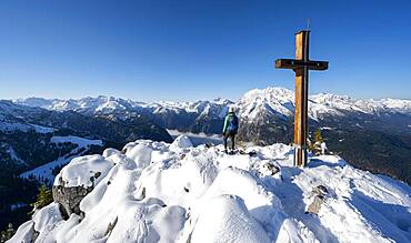 Hiker at the summit of the Jenner with summit cross, behind Watzmann, Berchtesgaden National Park, Berchtesgaden Alps, Schoenau am Koenigssee, Berchtesgadener Land, Bavaria, Germany, Europe