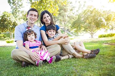 Attractive young mixed-race family portrait in the park