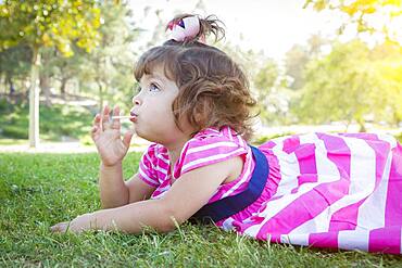 Cute baby girl enjoying her lollipop outdoors